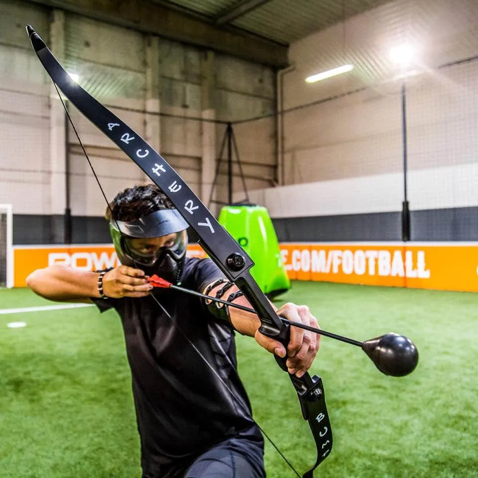 Joueur d'archery tag bandant son arc