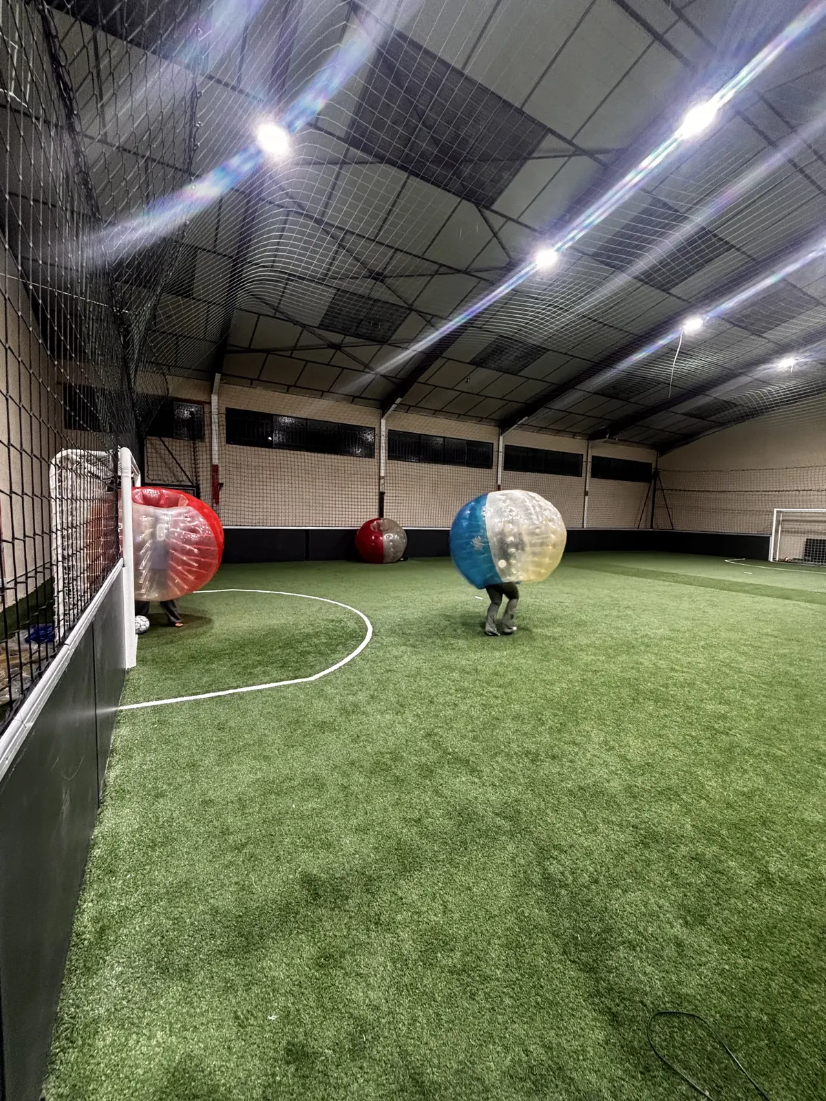 Joueurs en bulles près du but, sur le terrain indoor